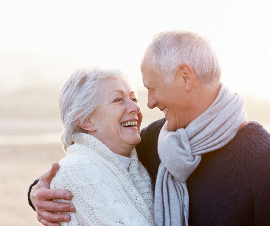 Man embracing a woman and both are smiling
