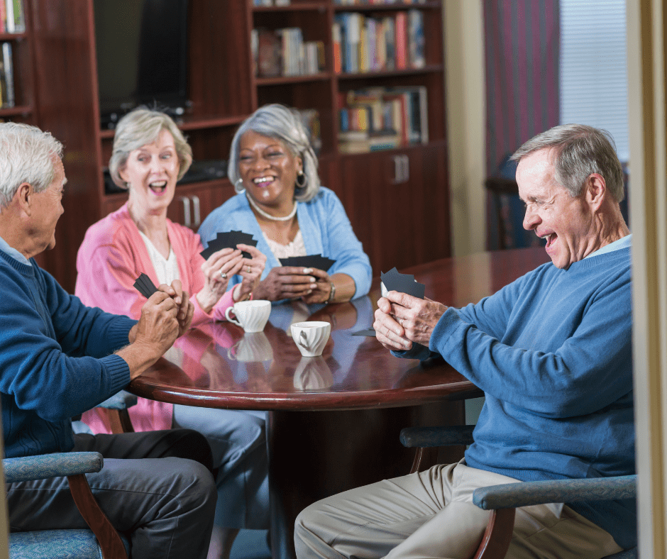 Group of diverse seniors playing cards in a library
