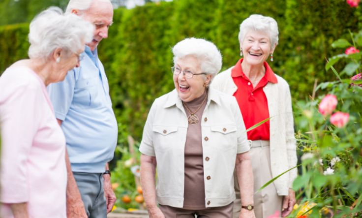 Group of seniors outside walking and laughing