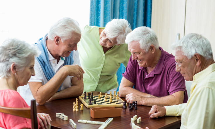 Group of seniors playing chess and dominoes